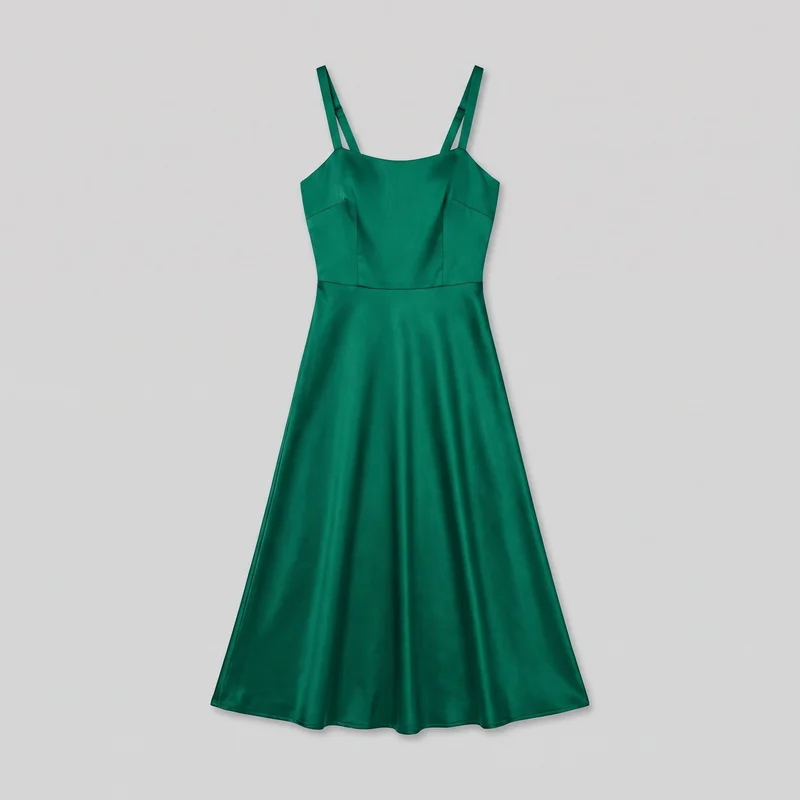 Emerald satin sleeveless midi dress shown laid flat in a complete front view. It has a fitted bodice with a shallow square neckline, double adjustable shoulder straps on each side, vertical shaping seams, angled bust seams, and a horizontal waist seam, with a flared A-line skirt falling to a simple midi-length hem.