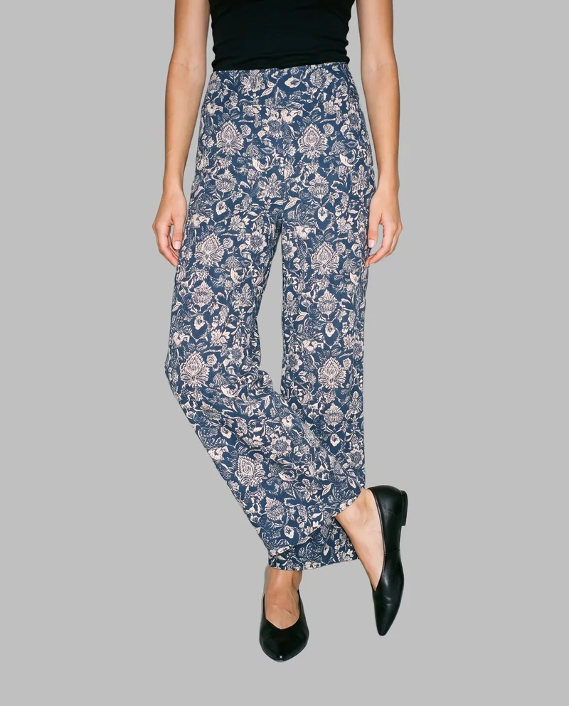 Printed palazzo trousers shown in a front-view lower-body composition, with one heel lifted. The trousers are presented against a flat Silver Mist backdrop.