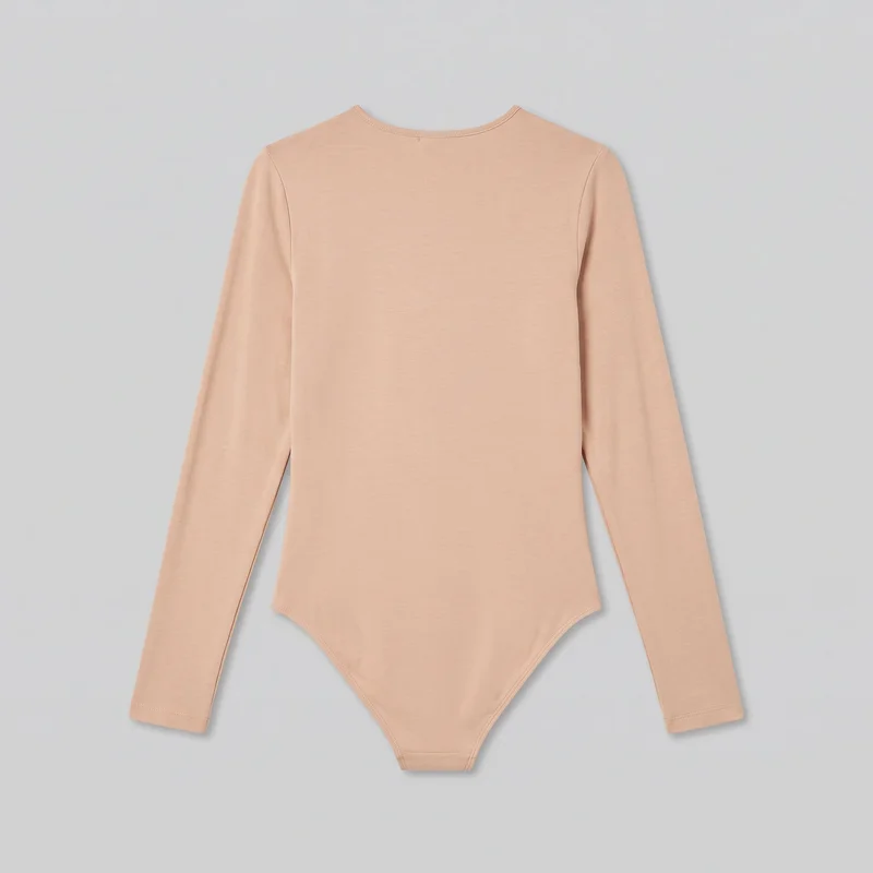 A complete front flat-lay view of a nude long-sleeve bodysuit. It has a rounded crew neckline with narrow stitched binding, a smooth close-to-body torso, set-in shoulders, full-length narrow sleeves with straight stitched cuffs, and high-cut curved leg openings with stitched edging. The centered crotch panel is visible, with no closure, logos, prints, patches, embroidery, or embellishments shown.