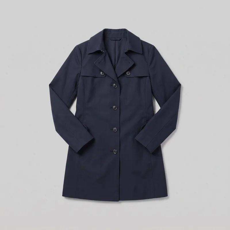 A navy women's longline trench-style coat is laid flat in a mostly complete front view. It has a tailored straight silhouette, set-in shoulders, long straight sleeves, a wide pointed turn-down collar, notched lapels, a single-breasted button closure with an overlapping placket, horizontal chest storm flaps, lower front pocket openings near the side seams, visible topstitching, and a straight hem.