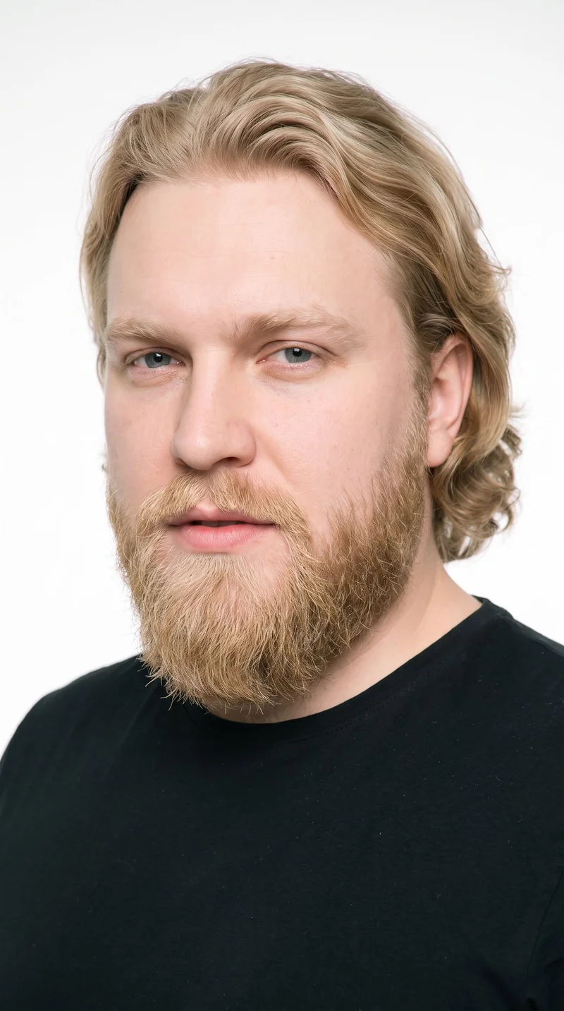 A 37-year-old Slavic man with pale skin and a peach undertone has an oval face with balanced proportions and a softly rounded jaw. His thick eyebrows frame blue eyes with a cool undertone, and he has medium lips. Medium-to-long blonde hair is brushed back with body and movement extending past the ears. A full beard grows evenly and continuously across his cheeks, jaw, and chin.