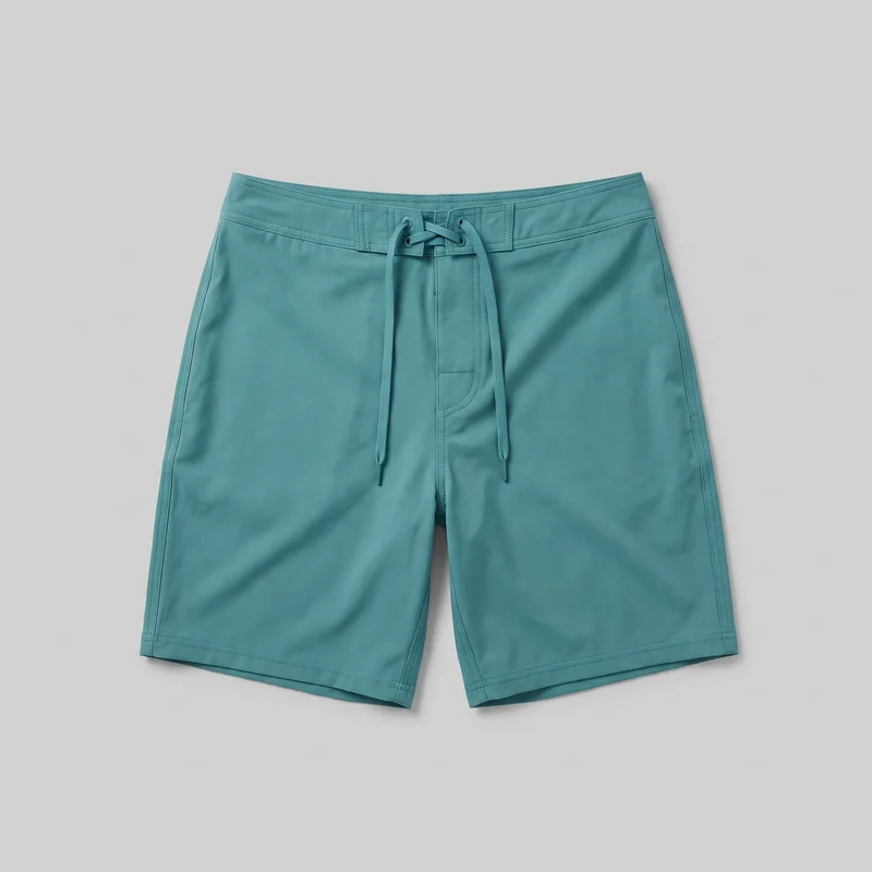 Teal men's board shorts shown flat in a standalone front view. The shorts have a regular straight-leg fit, a fixed segmented waistband, a front lace-up drawcord closure through paired eyelets, a central fly-style placket panel, visible side seams, reinforced double stitching, and straight knee-length hems. No logos, prints, patches, embroidery, or embellishments are visible.