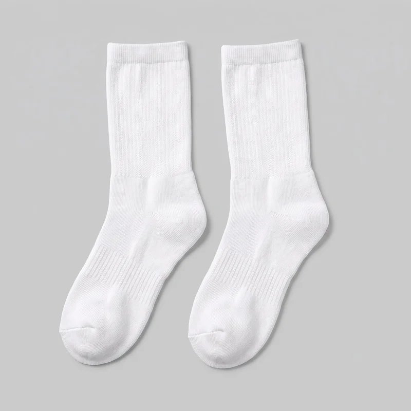 A matching pair of white crew socks is laid flat with the full sock shape visible. Each sock has a ribbed top cuff, straight tubular leg, shaped heel, rounded closed toe with a visible seam, and subtle vertical texture through the leg and foot. The socks have a plain exterior with no visible logos, prints, patches, embroidery, or embellishments.