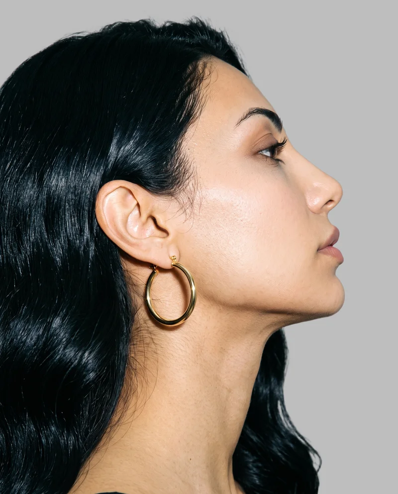 Women's Gold Hoop Earrings, Ear at Side, Studio Cutout lighting