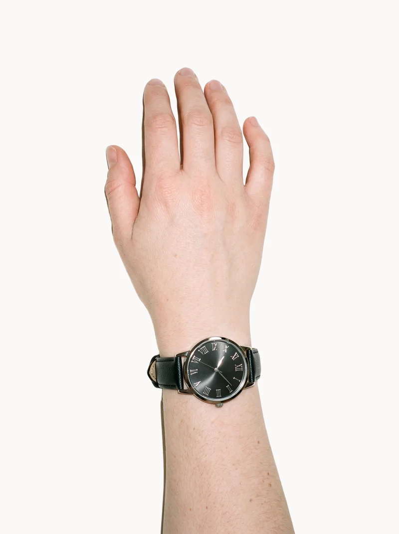 Women's Black Leather Dress Watch, Hand and wrist at Top, Studio Cutout lighting