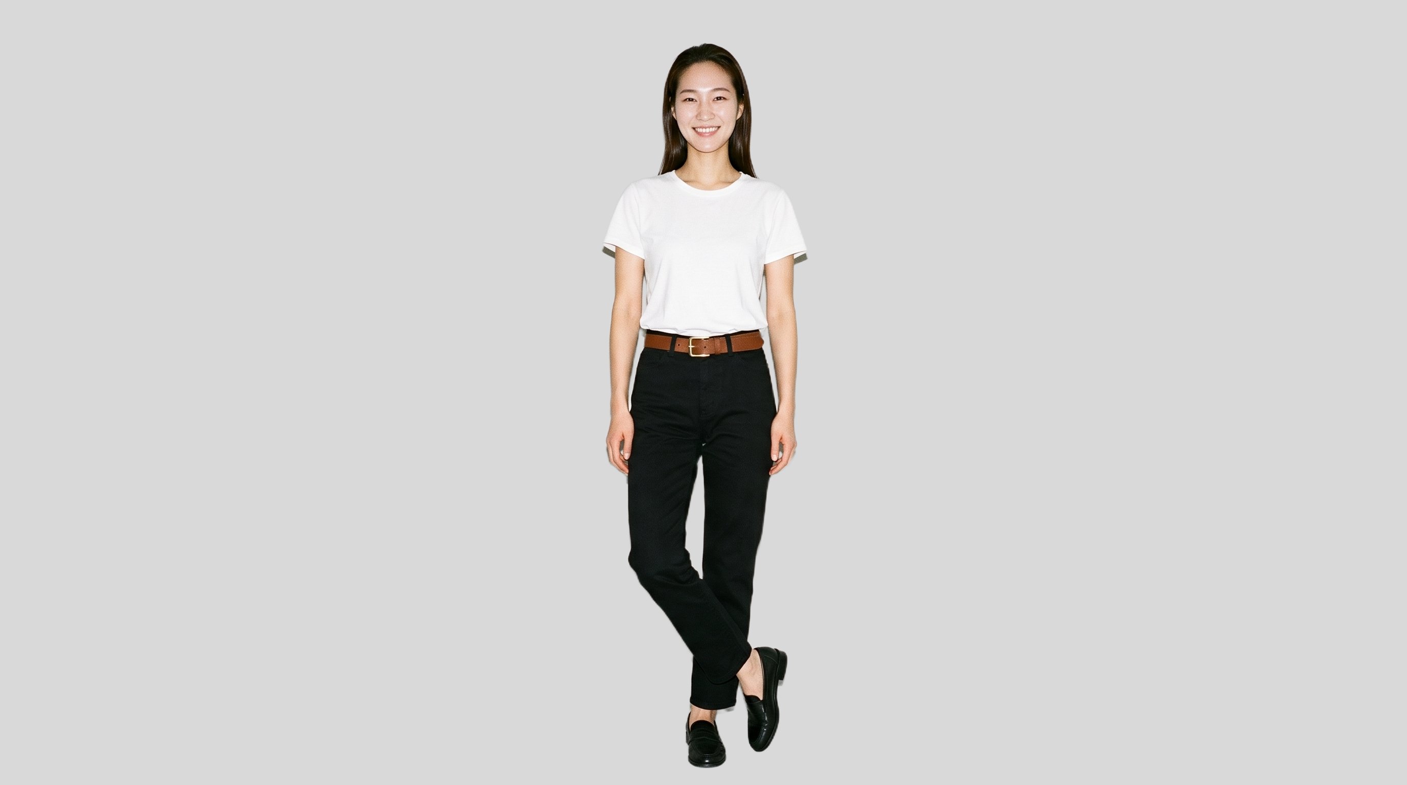A 26-year-old Korean woman is shown full body from the front, smiling with her ankles crossed while wearing a gold-buckle statement belt. The figure is presented against a flat pearl grey backdrop.