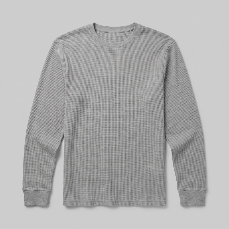 A mostly complete front view of a grey waffle-knit long-sleeve crewneck shirt laid flat. The regular-fit shirt has set-in shoulders, full-length sleeves, a ribbed crew neckline, ribbed cuffs, visible shoulder and armhole seams, and a straight hem.