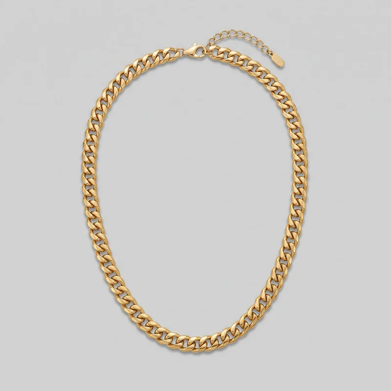 A complete gold curb-link chain necklace is laid out in a rounded loop. Its repeating flattened oval links have smooth domed surfaces, with the lobster-claw clasp, extender chain, and terminal end tag visible at the top.