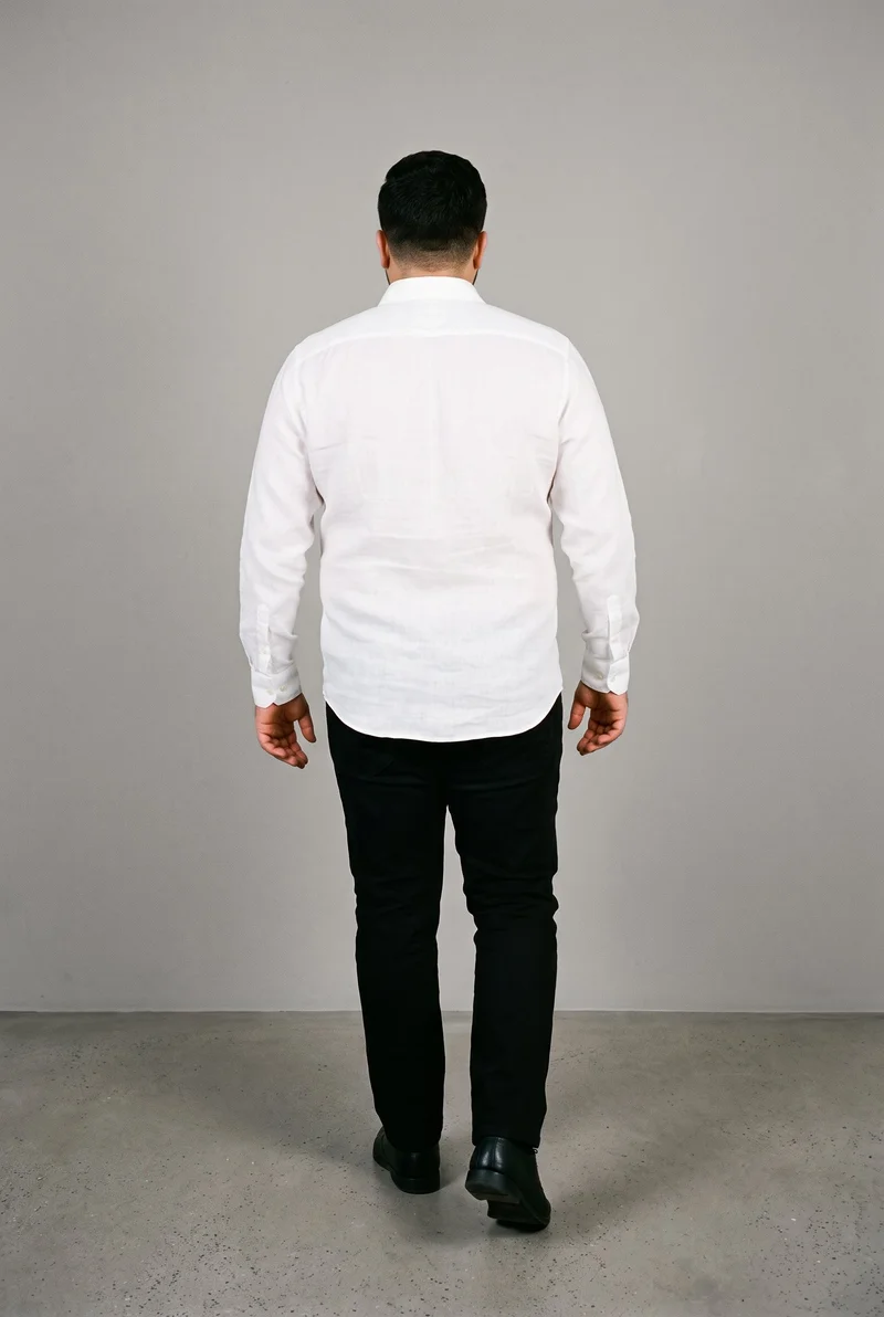 A 26-year-old Arab male model is shown full body from the rear while walking, wearing a white linen shirt. The shirt is presented against a Couture Grey studio-wall backdrop.