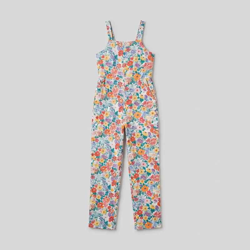 A complete front flat-lay view of a sleeveless one-piece jumpsuit with wide shoulder straps, a square neckline, low-cut arm openings, and a defined waist seam. Its fitted bodice has a central front seam or panel line and subtle pleat or gather lines below the waist, while the straight full-length legs end in straight hems. A dense all-over floral and leafy print covers the straps, bodice, and legs.
