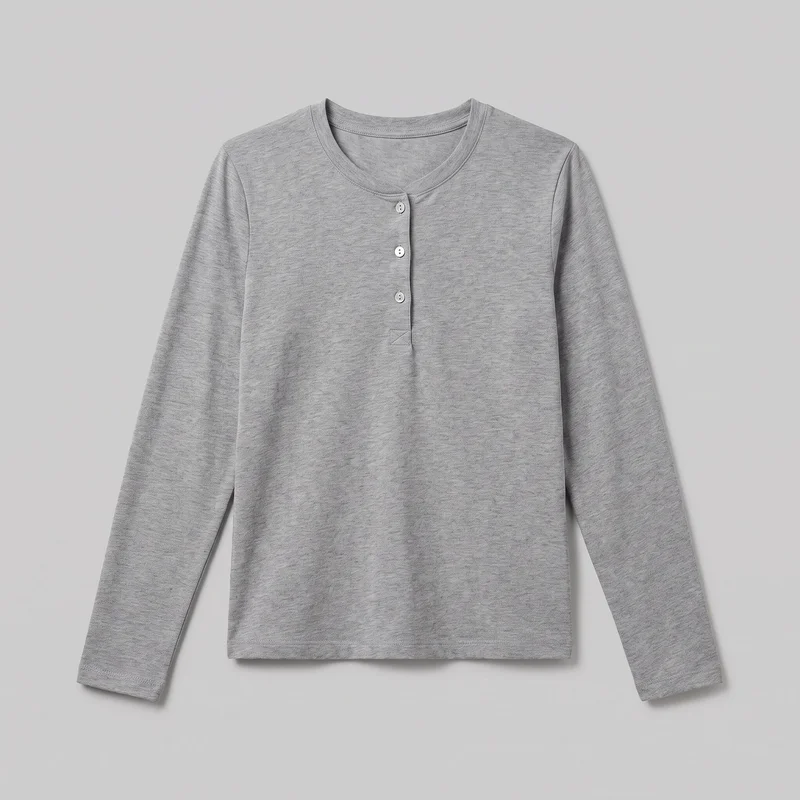 A grey cotton long-sleeve henley top is laid flat in a standalone front view. It has a straight silhouette, round crew-style neckline, set-in shoulders, full-length sleeves, straight body, and straight bottom hem. The short center placket has three visible buttons, stitched edges, and a reinforced box stitch at its base; stitched finishing is also visible around the neckline, sleeve hems, and bottom hem. No pockets, logos, prints, patches, embroidery, or embellishments are visible.