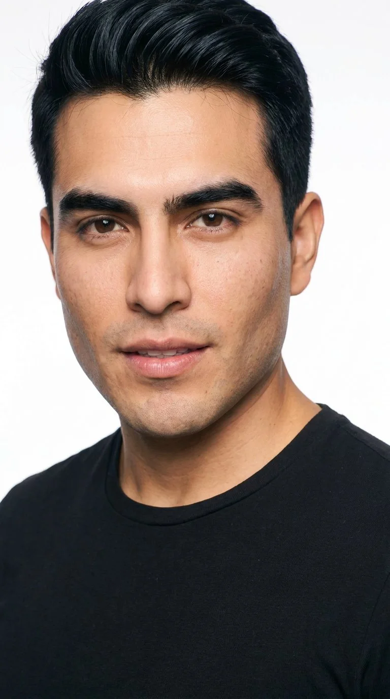 A 32-year-old Hispanic man with medium skin and a warm golden undertone has a diamond-shaped face, with a narrow forehead and jaw and cheekbones as the widest point. He has thick eyebrows, brown eyes, and thin lips. His deep black hair is styled in a taper, gradually shortening at the sides and neckline while retaining length on top. He is clean-shaven, with smooth skin across the entire face.