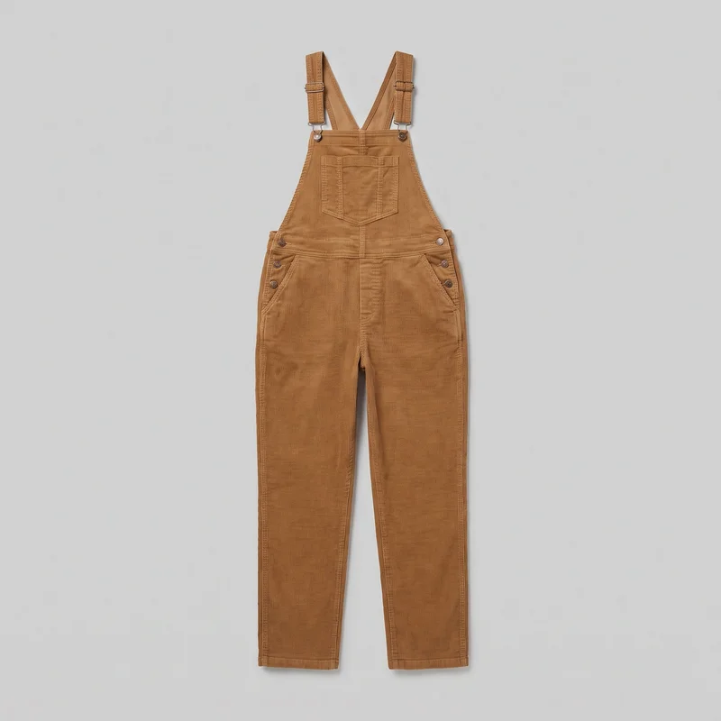 Women's corduroy bib overalls are shown laid flat in a complete front view. The garment has a straight-across bib with a patch pocket, wide adjustable shoulder straps with metal sliders, metal button fastenings, side waist buttons, slanted front hip pockets, vertical seams, full-length straight legs, and plain folded hems. The fabric has an all-over vertical ribbed texture.