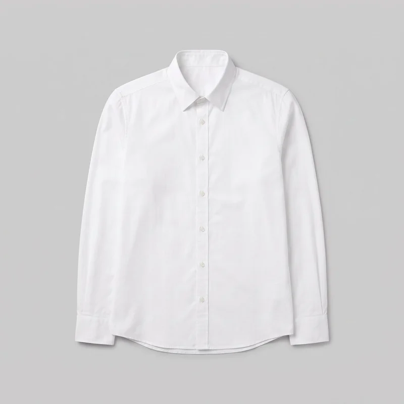 A white adult collared button-up shirt is shown in a mostly complete front view, laid flat or ghost-displayed. It has a pointed turn-down collar, a full-length front placket with visible round buttons, standard long sleeves with button cuffs, and a curved shirttail hem. No chest pockets, logos, prints, patches, embroidery, or other embellishments are visible.