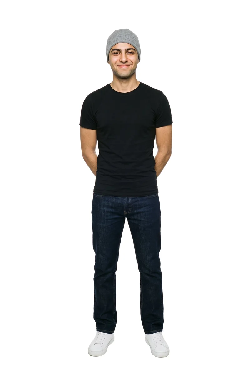 An 18-year-old Arab man wearing a grey kufi is shown in a full-body front view, smiling with his hands behind his back. A pure white backdrop frames the studio-cutout photograph.