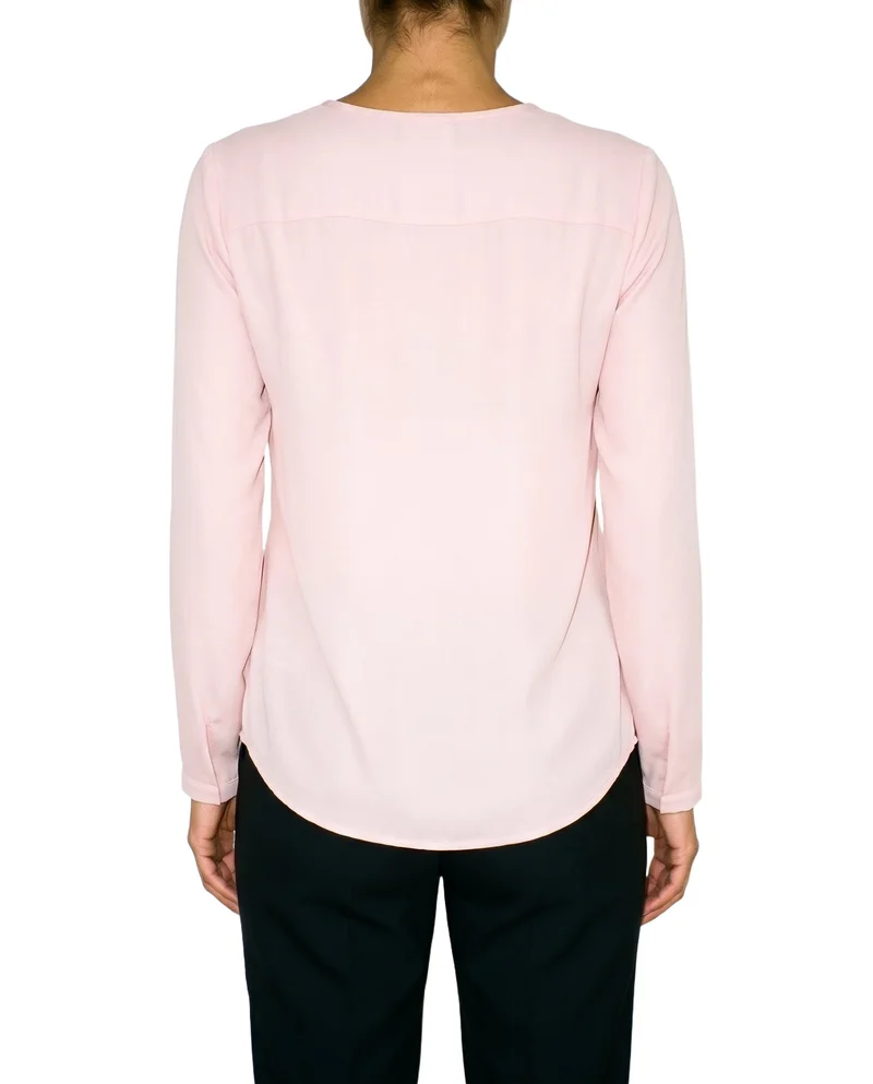 A torso-framed rear view of a blush pink chiffon blouse, shown with the model’s arms relaxed against a pure white backdrop.