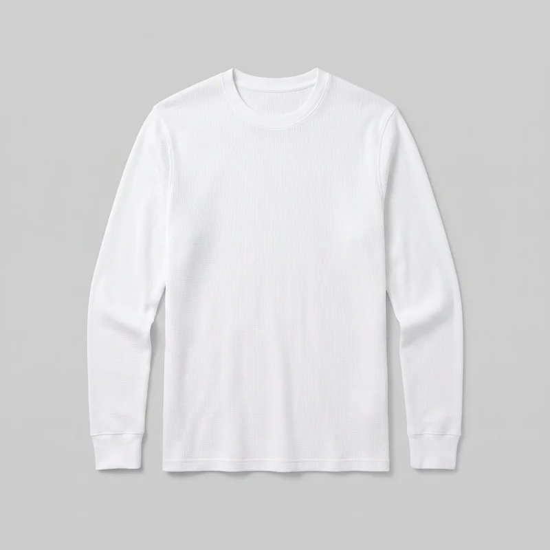 A complete flat view of a men's white base-layer thermal top with a straight silhouette, crew neckline, set-in long sleeves, and wide cuffs. The body and sleeves have an all-over fine vertical waffle or rib texture, with visible side seams and a narrow bottom hem band; no closures, pockets, logos, prints, embroidery, patches, or embellishments are visible.