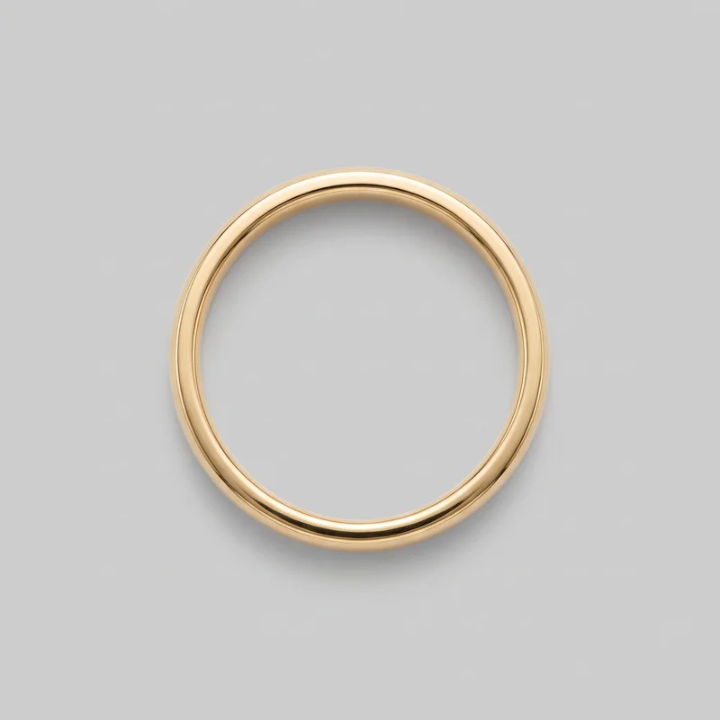 A single plain gold band ring is shown face-on as a complete circular loop. It has a smooth polished surface, a domed exterior, subtly rounded edges, and no visible stones, engravings, logos, or other embellishments.