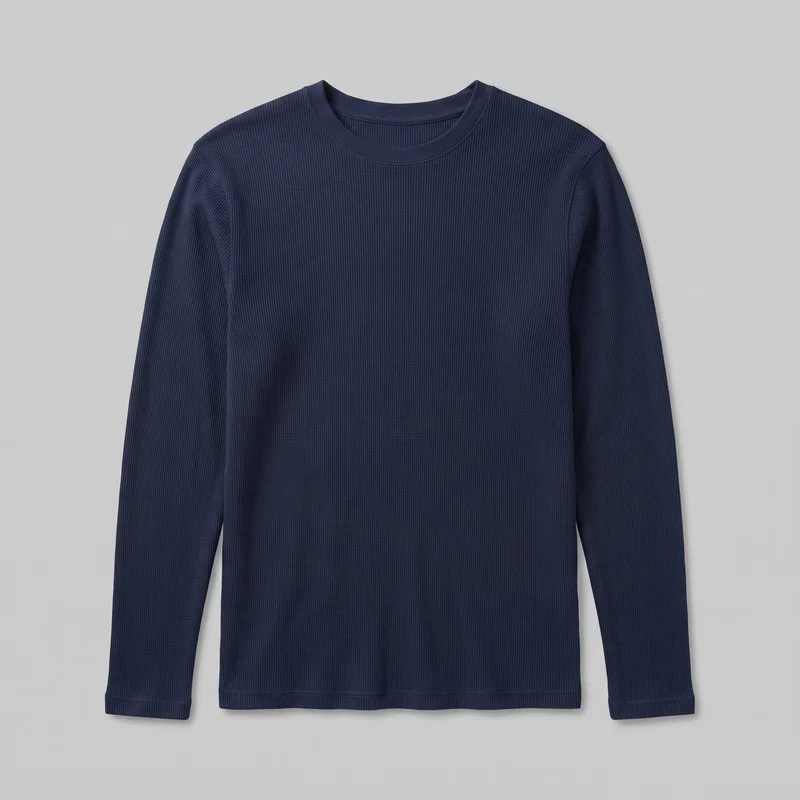 A men's navy long-sleeve thermal top is shown alone from the front, mostly complete from the crew neckline to the straight hem, with both sleeves visible. The top has a close regular silhouette, a narrow bound neckband, set-in shoulders, stitched sleeve cuffs, visible shoulder and armhole seams, and an all-over fine vertical rib texture. No closures, pockets, logos, prints, patches, embroidery, or embellishments are visible.