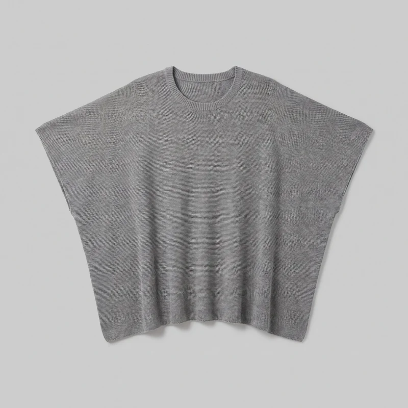 Grey poncho-style knit top shown laid flat in a standalone front view. It has a relaxed boxy shape, a round ribbed crew neckline, wide dropped shoulders forming very short sleeves, a cropped straight hem, and a loose draped body with a fine knit texture.