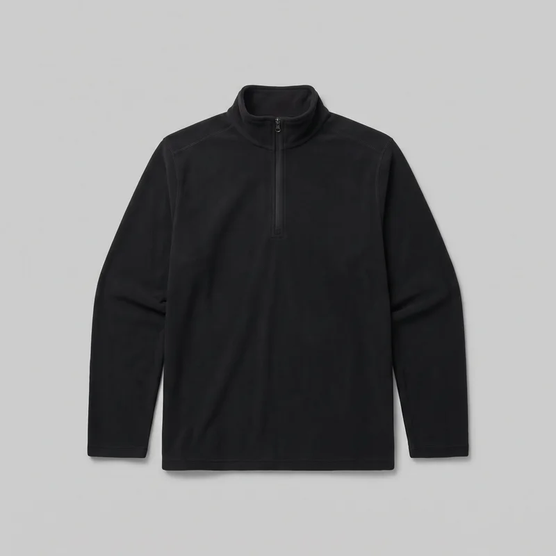 A black men's long-sleeve half-zip pullover is shown as a standalone front view. It has a high stand collar, a short center zipper with a visible pull tab, angled shoulder and upper-chest panel seams, full-length sleeves with finished cuffs, a straight silhouette, and a plain straight hem.