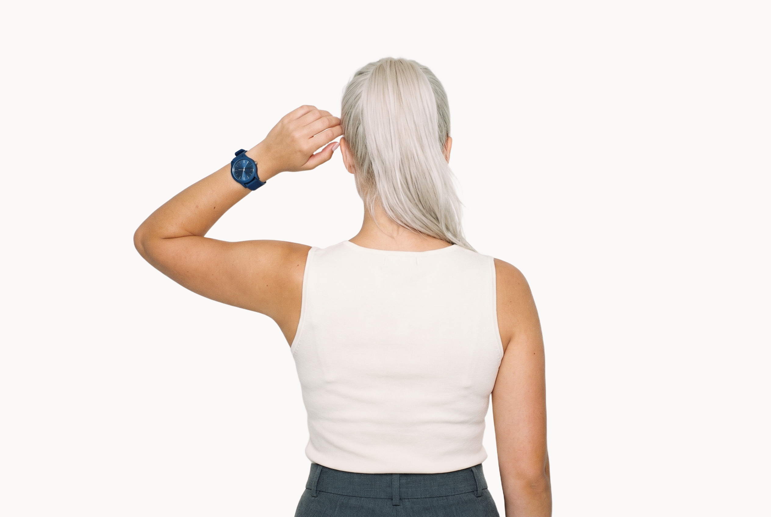 A 21-year-old Caucasian woman is shown from the back in an upper-body composition, with one hand raised to her temple and the navy rubber-strap sports watch visible on her wrist. A flat Chantilly Lace backdrop surrounds the subject.