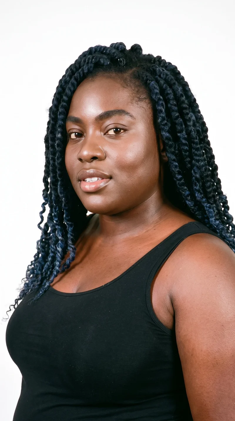 A 33-year-old African woman with dark-brown skin and a red-copper undertone. Her face has an angular structure with sharply defined cheekbones and jawline, framed by thick eyebrows. She has brown eyes and medium-sized lips. Her black hair is styled in soft, rope-like passion twists with a loose, textured finish.