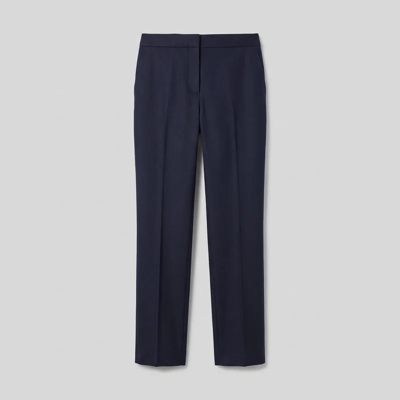 Women's navy wool tailored trousers shown in a mostly complete front flat-lay view. The trousers have a structured waistband, concealed center fly, slanted hip pocket openings, straight full-length legs, vertical side seams, sharp pressed front creases, and plain finished hems.