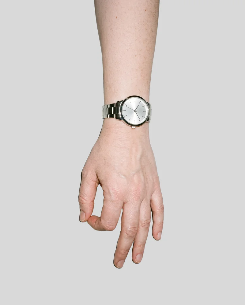 Women's Silver Analogue Watch, Hand and wrist at Top, Studio Cutout lighting