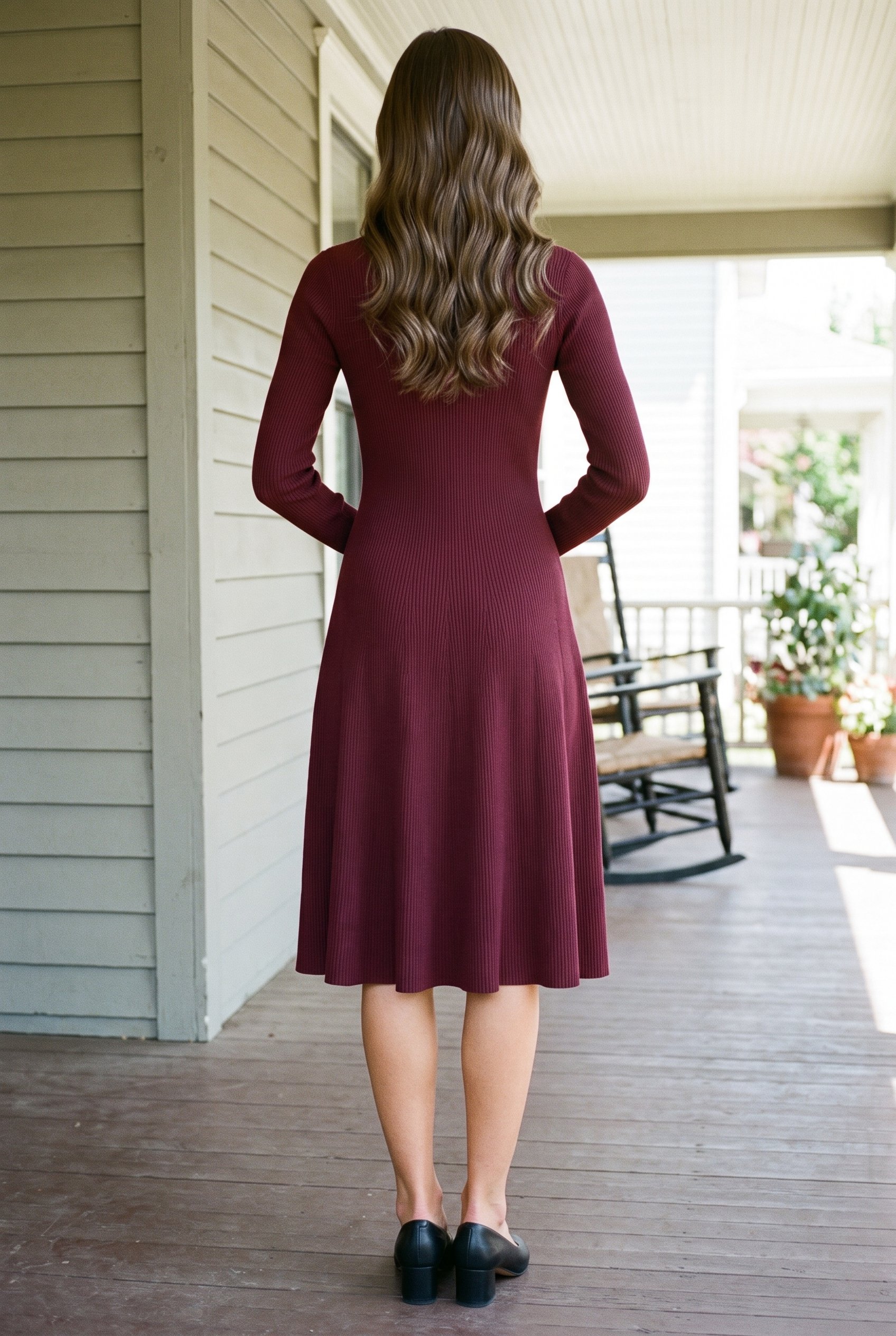 A 21-year-old Caucasian woman is shown full body from the rear wearing a burgundy knit midi dress, with her hands behind her back. A front porch backdrop frames the composition.