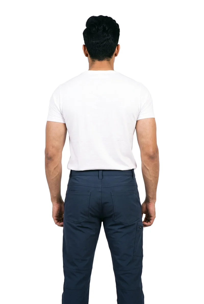 A 28-year-old Indian man stands straight, shown from the rear in a three-quarter-length view, wearing navy hiking trousers. The trousers are presented against a pure white backdrop.