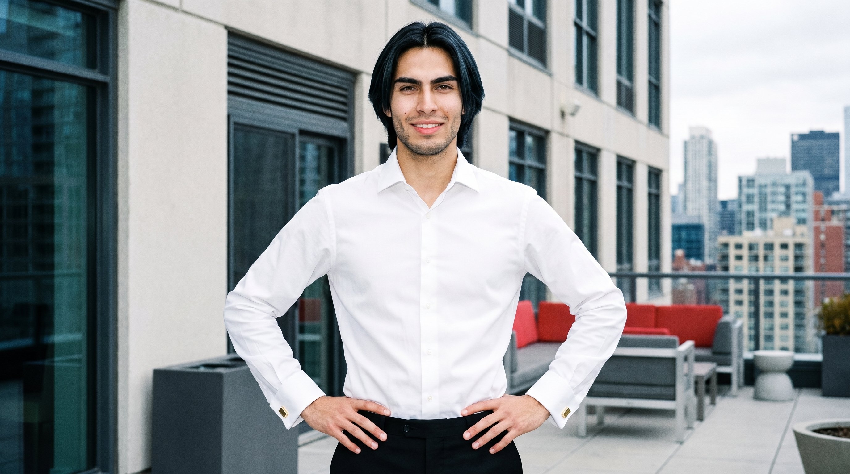 An 18-year-old Hispanic man is shown from the front in an upper-body view with his hands on his hips, wearing gold classic cufflinks. His natural expression is visible against a penthouse terrace backdrop.