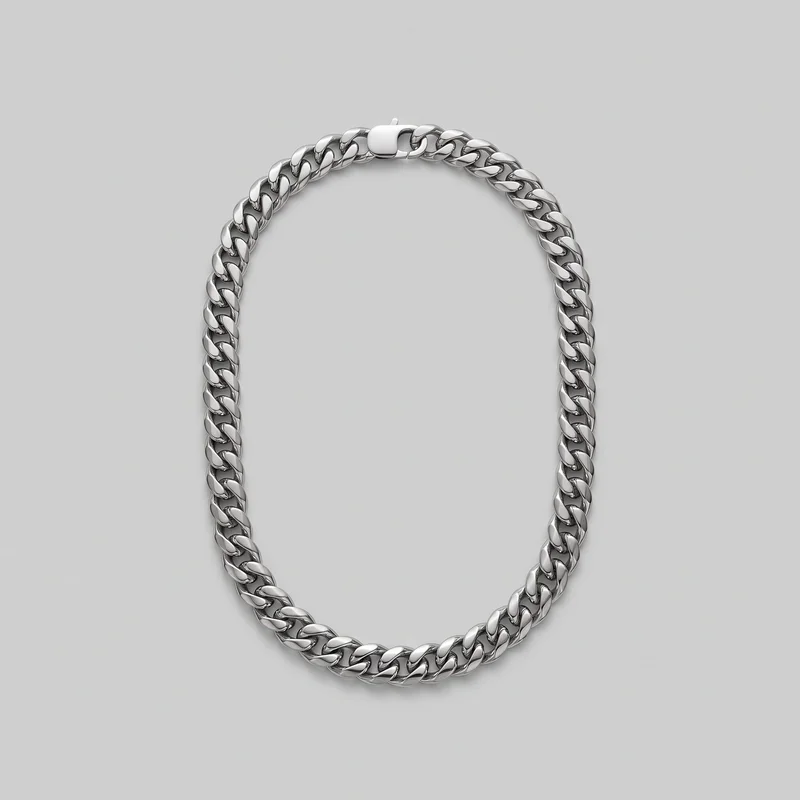 A complete Cuban link chain necklace is shown flat as a continuous oval. Broad, rounded interlocking curb links form a uniform-width chain with visible open gaps and darker recessed inner spaces, while a smooth rectangular box-style clasp sits at the top. No pendant, charm, logo, print, or other embellishment is visible.