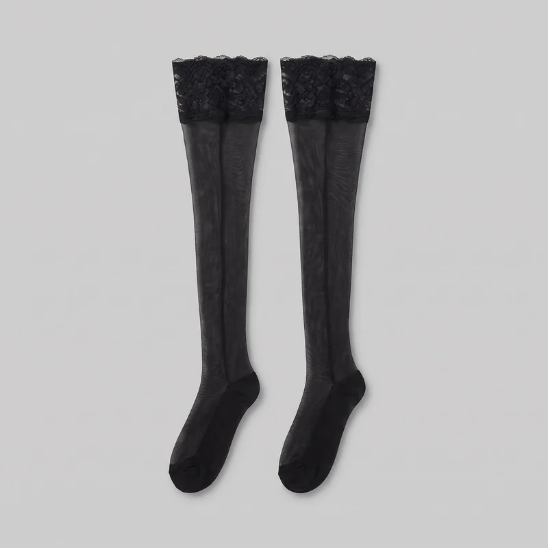 A matching pair of black thigh-high stockings is shown flat and mostly complete. Each stocking has a sheer, close-fitting leg, a wide upper lace band with a scalloped edge and floral pattern, and a shaped foot with a darker heel and reinforced opaque toe area.