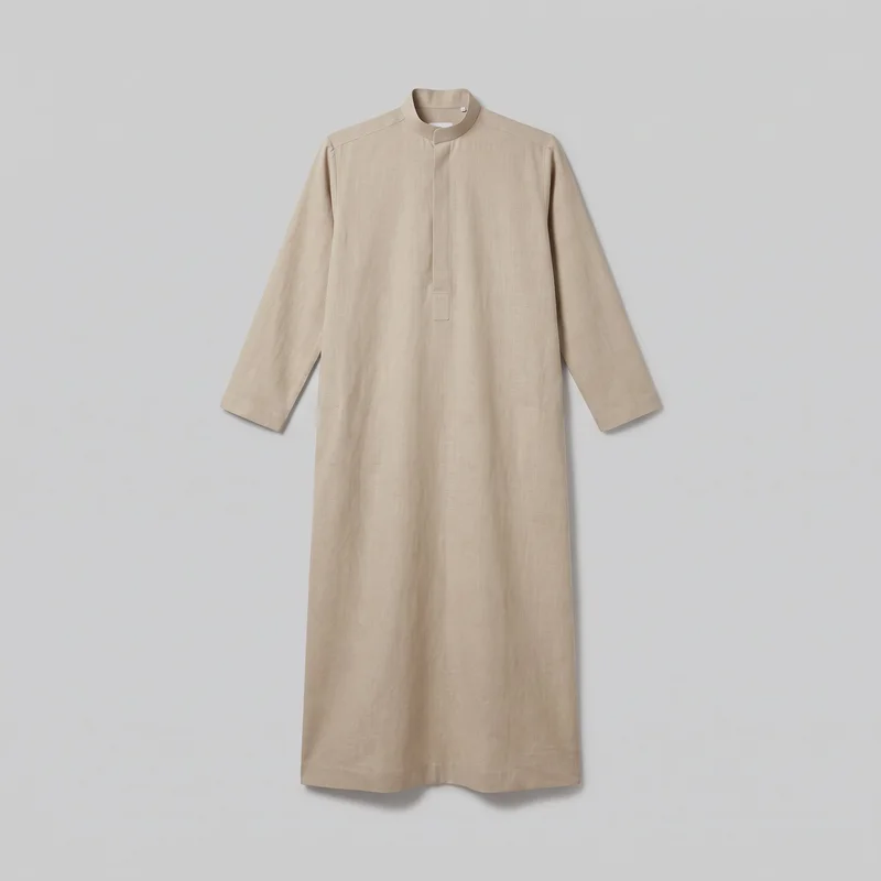 A beige linen thobe is shown laid flat in a complete front view against a plain backdrop. The full-length one-piece garment has a relaxed straight fit, band collar with a split neckline, partial concealed front placket, regular shoulder seams, full-length straight sleeves, an ankle-length column silhouette, and a straight bottom hem. Shoulder yoke seams, a stitched rectangular tab near the lower end of the centered placket, simple sleeve hems, and a clean stitched hem are visible; no pockets, logos, prints, embroidery, or embellishments are visible.