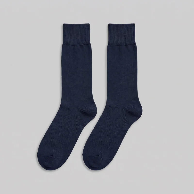 A complete pair of plain navy calf-length dress socks is shown flat, with the ribbed cuffs at the top, straight tubular legs, smooth knit shafts and feet, shaped heels, and rounded closed toes. Visible toe seams and the plain knit surface are shown; no logos, prints, closures, patches, embroidery, or other embellishments are visible.