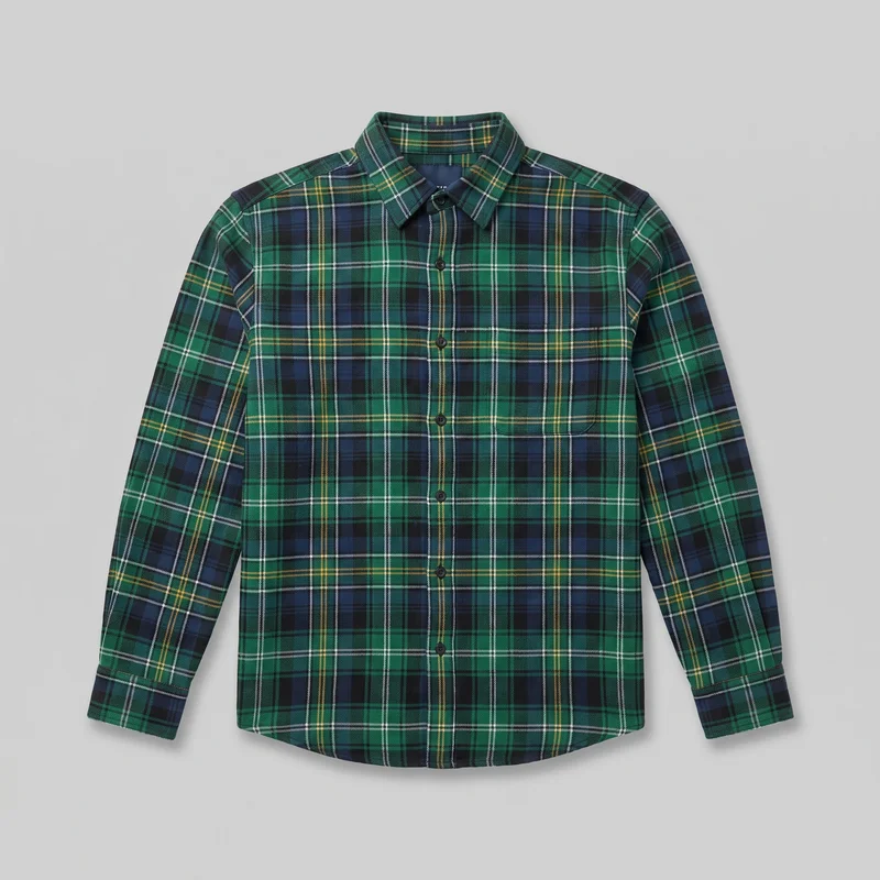 Green plaid long-sleeve button-up shirt laid flat in a standalone front view. It has a pointed fold-down collar, full front button placket, set-in shoulders, cuffed sleeves, a regular straight fit, and a slightly curved shirt-tail hem. The tartan-style plaid continues across the body, collar, sleeves, cuffs, and placket, with no visible chest pockets or embellishments.