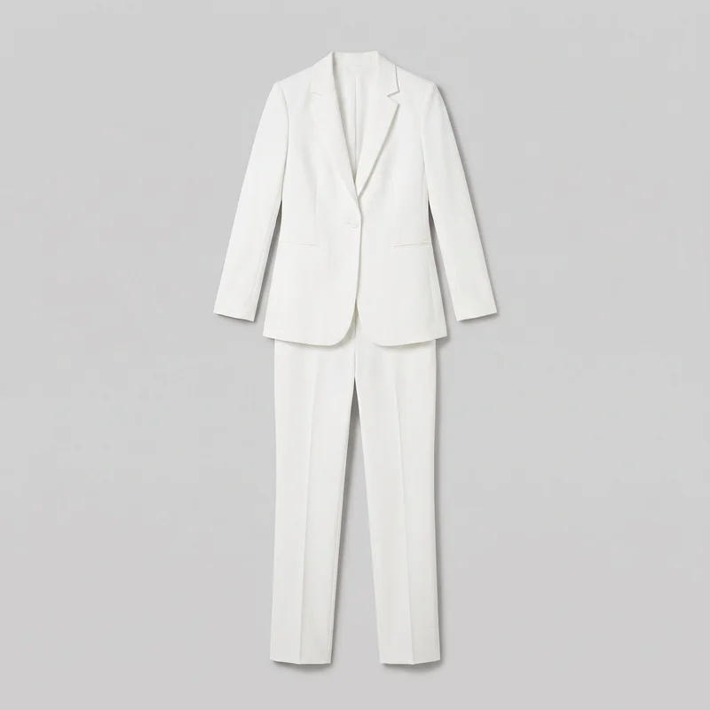 White two-piece tailored pantsuit laid out together in a full standalone front view. The hip-length single-breasted blazer has structured shoulders, long sleeves, notched lapels, a deep V front opening, one visible button, vertical shaping seams, horizontal welt pockets, and a curved hem. The coordinating trousers have a straight-leg cut, full-length hems, and pressed center creases.