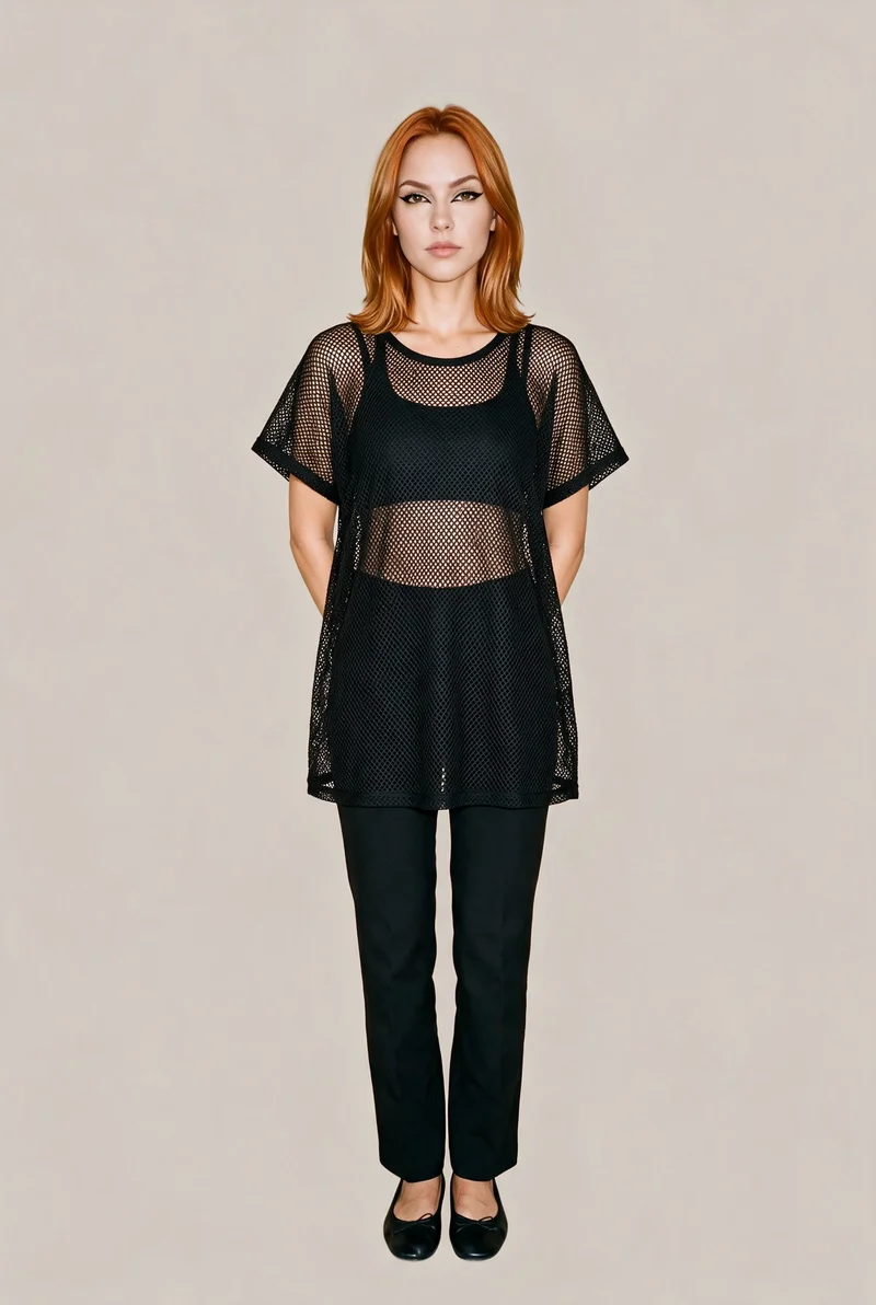 A 21-year-old Caucasian woman models a women's black mesh cover-up in a full-body, front-facing view. She stands with her hands behind her back and a neutral facial expression against a flat London Fog backdrop.