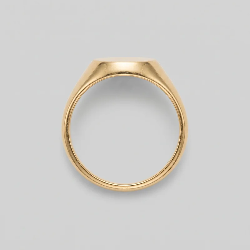 A gold signet-style ring is shown upright as a standalone object, centered with most of the ring visible. Its continuous rounded band broadens through sloped shoulders into a flat, squared signet head with smooth beveled planes. A subtle raised inner border follows the ring opening, and no stones, engraving, logos, prints, or other embellishments are visible.