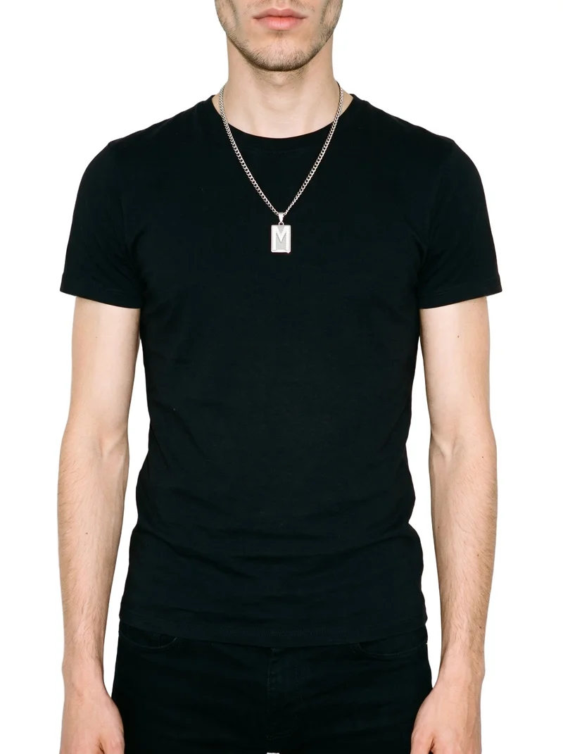 A male model is shown from the front in a torso-length view with his arms relaxed, wearing a men's diamond pendant. The pendant is presented against a pure white backdrop.