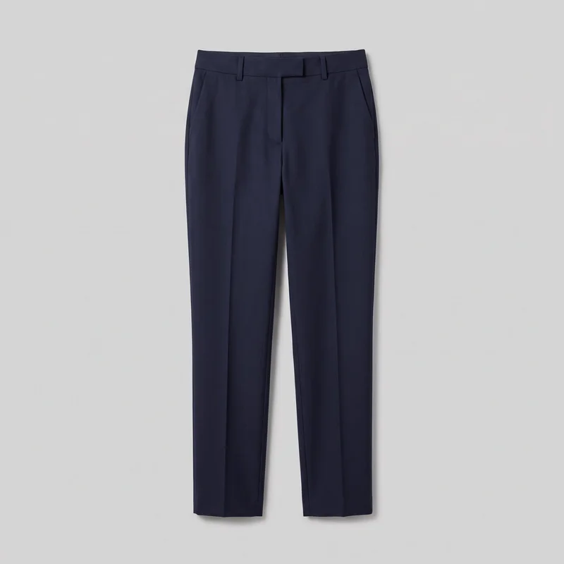 Navy wool suit trousers are shown in a full standalone front view. The tailored full-length design has a regular straight-leg fit, structured waistband with belt loops, concealed front fly with an extended waistband tab, slanted side pockets, front pleats, pressed center creases, and straight hems.