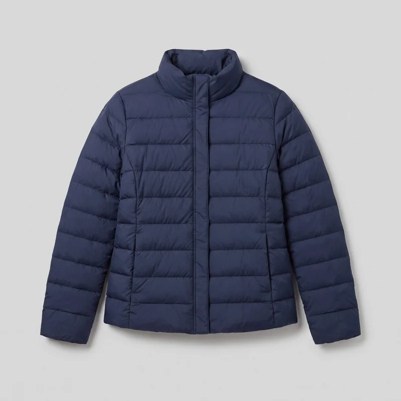 A mostly complete women's navy padded jacket is shown laid flat in a standalone front view. The hip-length jacket has horizontal quilted baffles across the body and full-length sleeves, a high padded stand collar, a smooth center-front storm placket, shoulder and yoke seams, vertical front panel seams, plain cuffs, two lower inset hand pockets, and a straight hem.