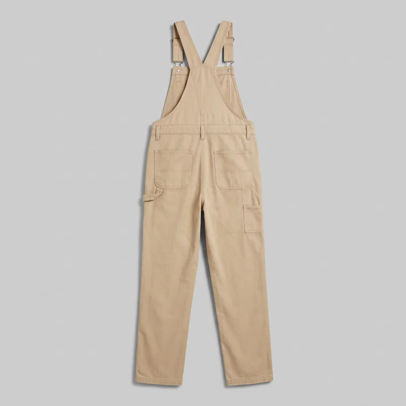 Women's khaki utility dungarees shown in a complete standalone back view. The bib overalls have crossed shoulder straps with visible metal adjusters and hooks, side hardware, a raised back bib, two rear patch pockets, a hammer loop, and a utility pocket, with full-length straight legs and stitched hems.