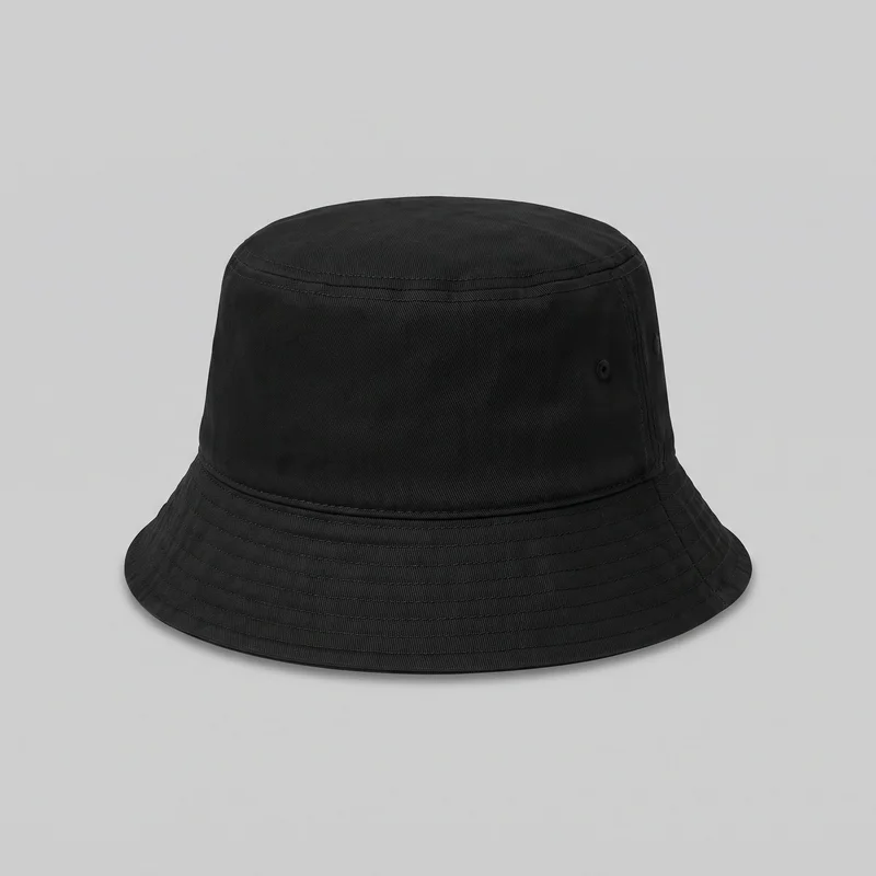 A black women's bucket hat is shown as a standalone product, with its full rounded silhouette visible. It has a cylindrical crown, flat circular top, circular crown seam, seam band near the top, a vertical side panel seam, and a small round side eyelet. The continuous downward-sloping brim features multiple parallel rows of concentric stitching, with no visible logos, prints, patches, embroidery, or embellishments.