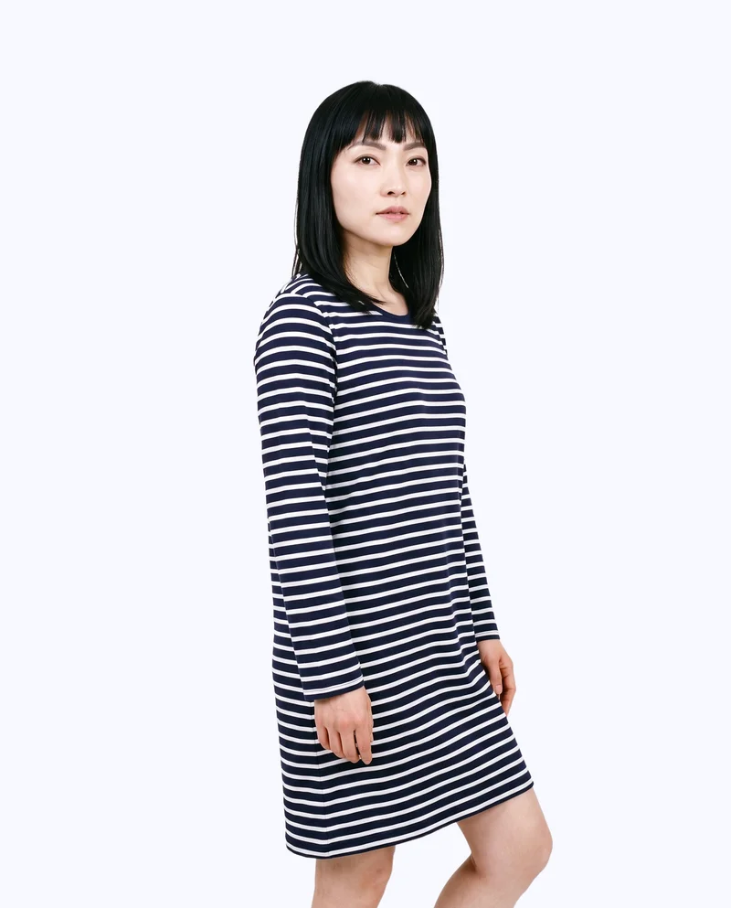 A 37-year-old Chinese woman wears a striped nightdress, shown from the front three-quarter angle in a three-quarter-length frame. She stands in a relaxed pose with a neutral expression against a flat porcelain-color backdrop.