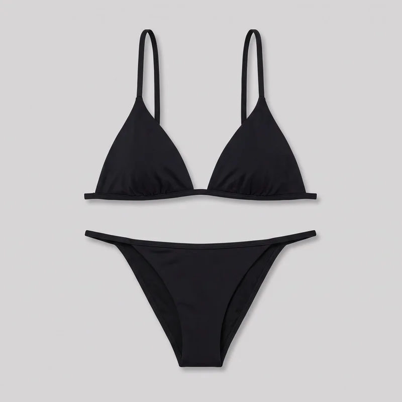 A standalone two-piece black triangle bikini set is shown flat, with the triangle top positioned above matching low-rise bottoms. The top has narrow fixed shoulder straps, gathered triangular cups, and a straight underbust band with a narrow horizontal extension at each side. The bottoms have narrow side straps, a pointed front panel, high-cut leg openings, and stitched binding around the waist and leg edges.