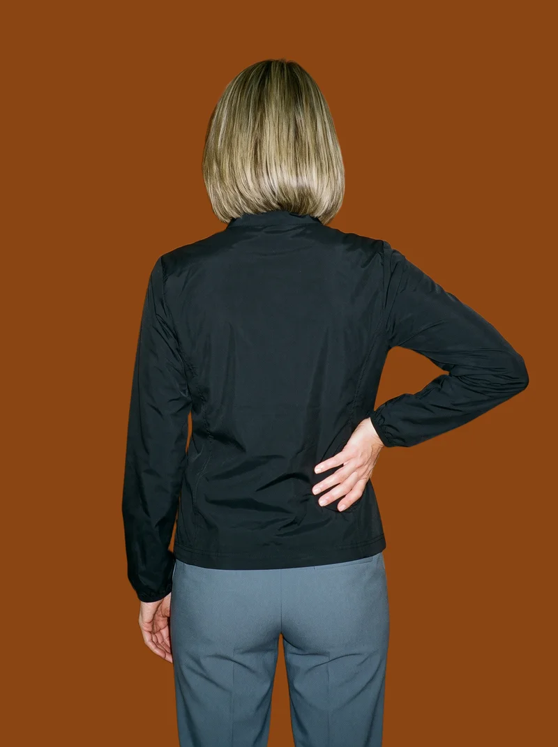 Women's Black Track Jacket, Three-quarter length at Back, Studio Cutout lighting