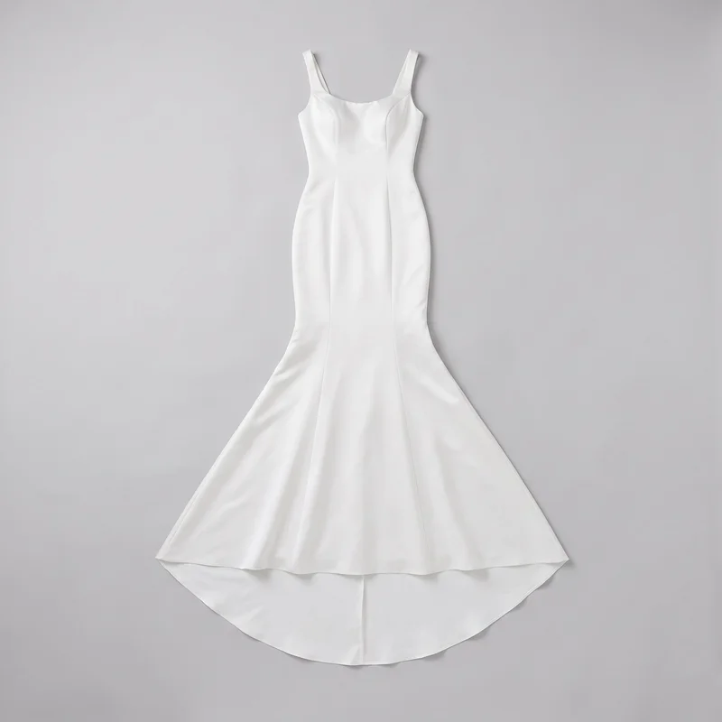 A mostly complete flat-lay view of a women's sleeveless satin wedding dress. The gown has wide shoulder straps, a soft square scoop neckline, a fitted bodice and waist with curved princess seams, and a close-fitting shape through the hips that flares into a floor-length mermaid skirt. Vertical panel seams continue down the skirt, with a center front seam, a curved front hem, and a longer rounded back train visible beneath it.