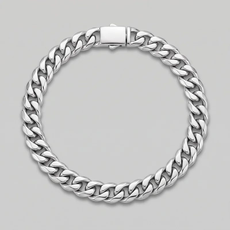 A complete Cuban link bracelet is laid in an oval shape. The bracelet consists of continuous interlocking curb links with flattened, rounded faces and open gaps between the links, with a rectangular box-style clasp visible at the top, including a side release tab and a small safety catch beneath the clasp.